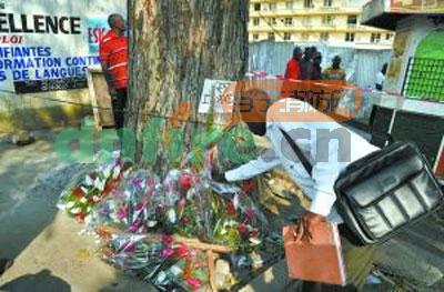 1月2日，一名男子在科特迪瓦阿比让踩踏事件发生地附近的街边摆放鲜花，悼念逝者